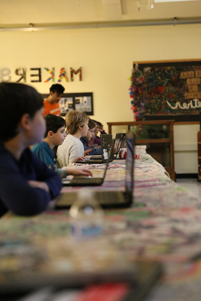 students working at laptops in a classroom